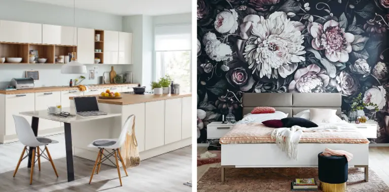Links helle Kuche mit Esstisch und offenen Regalen, rechts Schlafzimmer mit weissem Bett vor grosser Blumenwand, Hocker vorn
